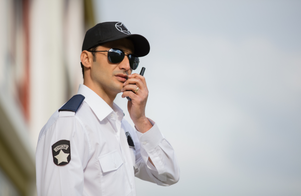 Security guard in uniform speaking into radio during patrol
