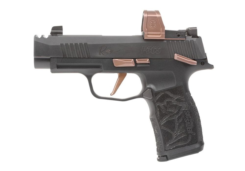 A black semi-automatic pistol with a textured grip and copper-colored accents, including the trigger and slide release. It features an optics-ready slide with a red dot sight mounted on top.