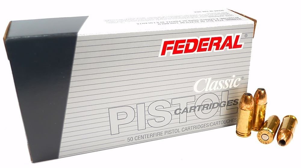 A box of Federal Classic pistol cartridges with three brass bullets displayed in front. The box is silver with red and gray accents, labeled clearly with the product name and quantity.